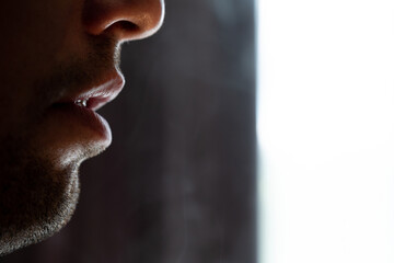 Seductive male lips blowing cigarette smoke.