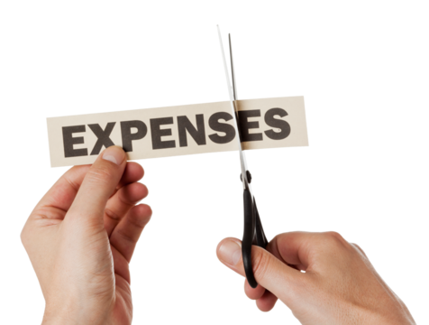 Cutting down expenses concept. Hand holding printed word, other hand with scissors isolated on transparent background