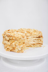 Napoleon cake in a cut on a white tray isolated on a white background. Cake of puff pastry with sour cream. Copy space. 