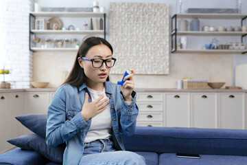 Young beautiful woman sick at home, having asthma and difficulty breathing, asian woman wearing...