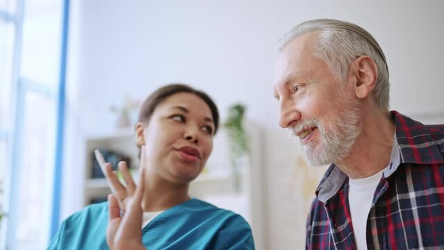 Female doctor explaining x-ray image results to senior man, diagnostic center