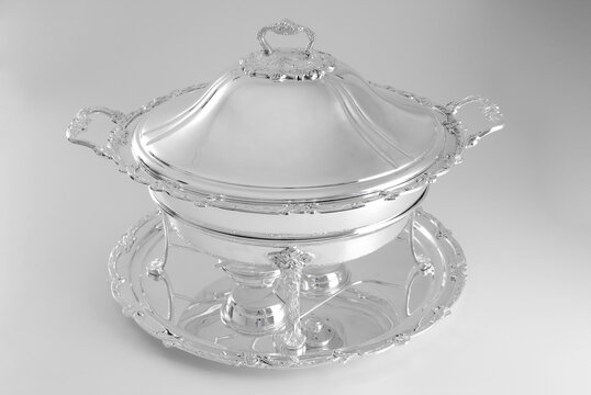 Antique round silver rechaud on a silver tray, isolated on white