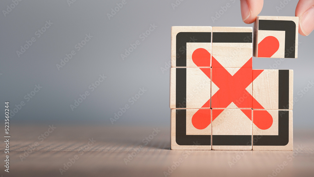 Poster red cross mark, x, wrong mark sign, rejection sign in wooden cube hand stacking. concept of negative