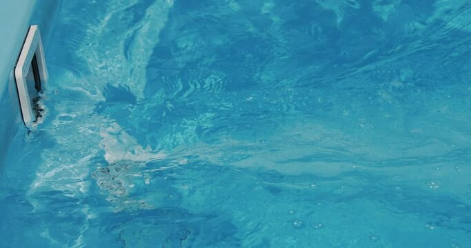 The countercurrent in the pool is a powerful flow of water. A swimmer can swim in a small pool. Side view