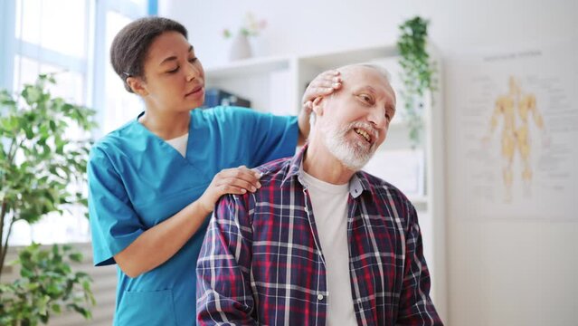 Female doctor examining neck of her senior patient, certified physiatrist