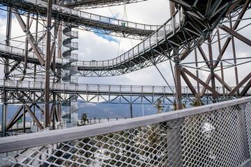 Dolni Morava, Czech Republic, 16 April 2022: Path in the clouds, tourist attraction with spiral platform to observation tower, landscape with forest and sky on mountains, Skywalk with snow