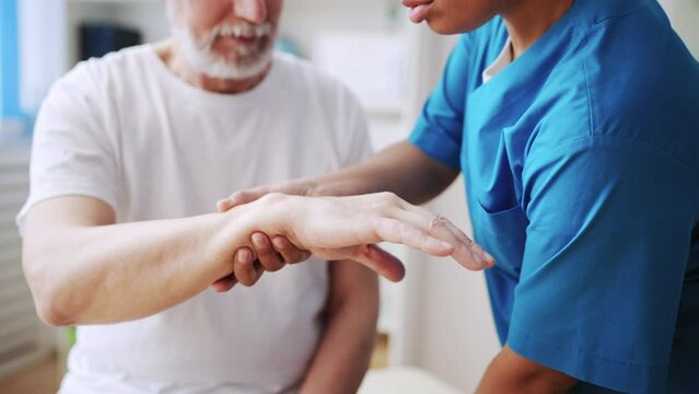 Closeup of orthopedist removing cast from patient's hand, bone fracture healing