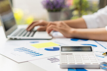 Fototapeta premium Close up hand man doing finance and calculate on desk about cost at home accountant working on desk using calculator for calculate finance report in office