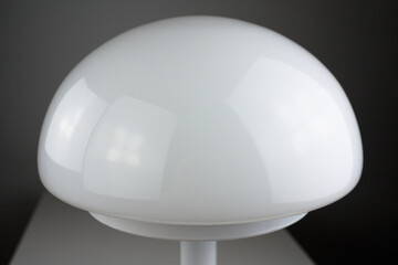 modern desk lamp with mushroom shape spaceage vintage midcentury design front side view white black background with warm orange light isolated in the studio living room creative HIGH RESOLUTION