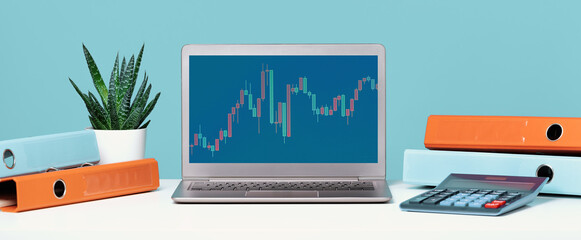 Stock exchange trade forex financial concept. Laptop with graphs headset on white desk with...