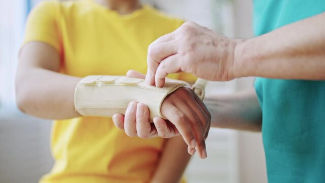 Closeup of traumatologist putting cast on patient's arm, injury treatment