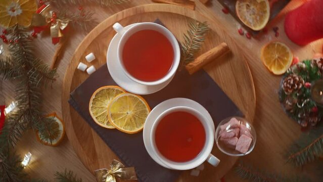 two cups of black or berry red christmas tea, decorated candle, top view flatlay