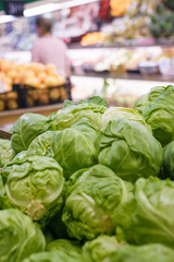 Fresh spring cabbage on counter, vegetable department in grocery store, supermarket, mall, hypermarket, shopping center. Vegetarian healthy food