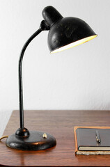 	
an antique black table lamp from the 20s bauhaus era standing on an old desk commode isolated on...