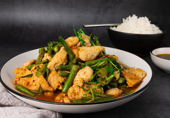  Tasty Stir-fried pork and red hot curry paste with asparagus bean or long bean and  Ingredients are oyster sauce, fish sauce, sugar, kaffir lime leaves in the dish Eat with cooked rice. Thai cuisine