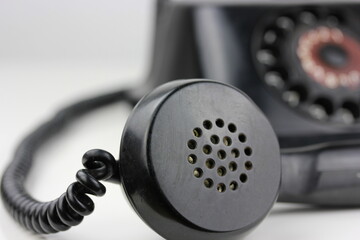 old antique dial operated telephone black out of bakelite on white background isolated side view...