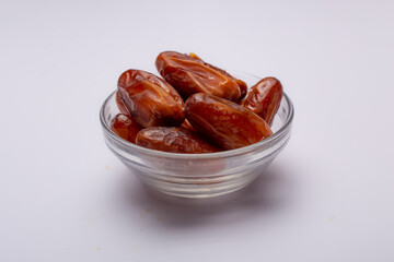 Bowl of pitted dates isolated on white background, top view
