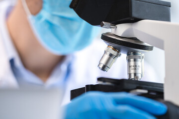 biotechnology scientist using scientific microscope for research in biology medicine laboratory, equipment for chemistry science or microbiology analysis in term of medical technology experiment