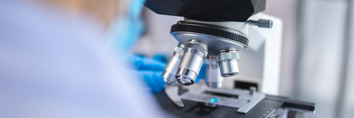 biotechnology scientist using scientific microscope for research in biology medicine laboratory,...