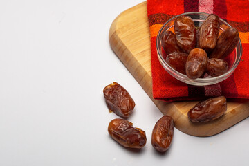 Bowl of pitted dates isolated on white background, top view
