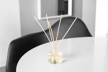 Handmade reed freshener on white table in living room, close up