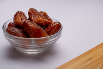 Bowl of pitted dates isolated on white background, top view
