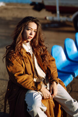 Stylish woman enjoying autumn weather outdoor. Fashion, style concept. People, lifestyle, relaxation and vacations concept.