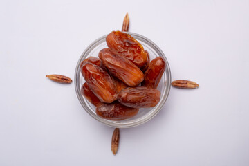 Bowl of pitted dates isolated on white background, top view
