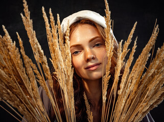 Closeup young charming redhead girl in image of medieval person in renaissance style in ears of...