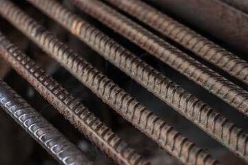 Stack of heavy metal reinforcement bars with periodic profile texture.