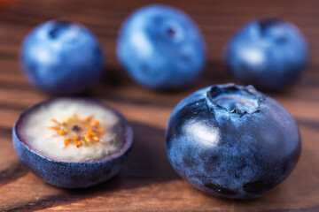 Fototapeta na wymiar fresh Blueberries with cut in half on wooden background.