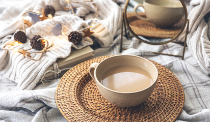 Cozy autumn composition with a big cup of coffee in bed.