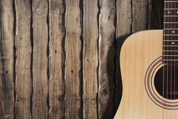 Obraz premium Acoustic guitar resting against a wall background