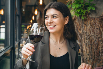 Attractive young woman with a glass of wine in a restaurant.