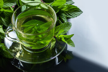 Tea in a glass cup, mint leaves, dried tea. herbs tea and mint leaves on a slate plate