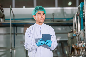 Asian man engineer factory Professional technologist using tablet in production plant checking...