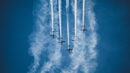Airplanes on the blue sky during airshow. Five aeroplane in formation. Air display team flying in...
