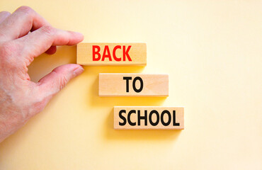 Back to school and support symbol. Concept words Back to school on wooden blocks. Businessman hand....