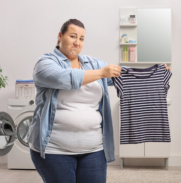 Woman Showing A Shrunken Shirt In A Bathroom