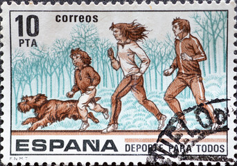Spain - CIRCA 1979: a postage stamp from Spain, showing a family with a dog running. Circa 1979