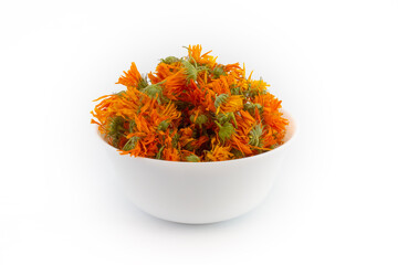 Dried orange calendula flowers in a ceramic white bowl isolated on white background. Pot marigold is medical herbs.