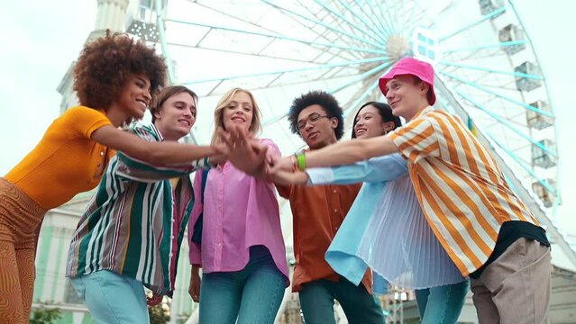 Multiethnic group of friends going out after school and having fun. teenagers meeting at the amusement park in the city
