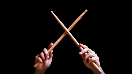 male drummer hands holding drumsticks in x shape. isolated on black - 523592899