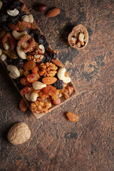 Mix of nuts and raisins on a brown rustic background.