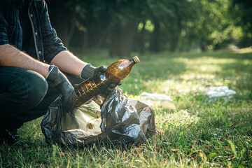 A man cleans the forest from garbage, the concept of caring for nature.
