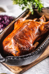 Goose feasts and roast goose in the oven on the festive table. © weyo