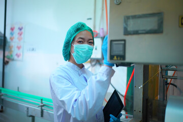 worker controlling the work of machine in production line at beverage industry.