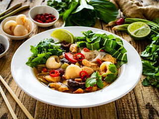 Yunnan hot pot - chinese soup with chicken meat on wooden table
