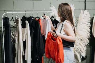 Sustainable fashion, slow fashion, Conscious shopping. Young Latina woman shopping in modern clothing store.