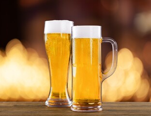 Beer is poured  into beer glass.  Lager beer foams and pours from bottle into glass.